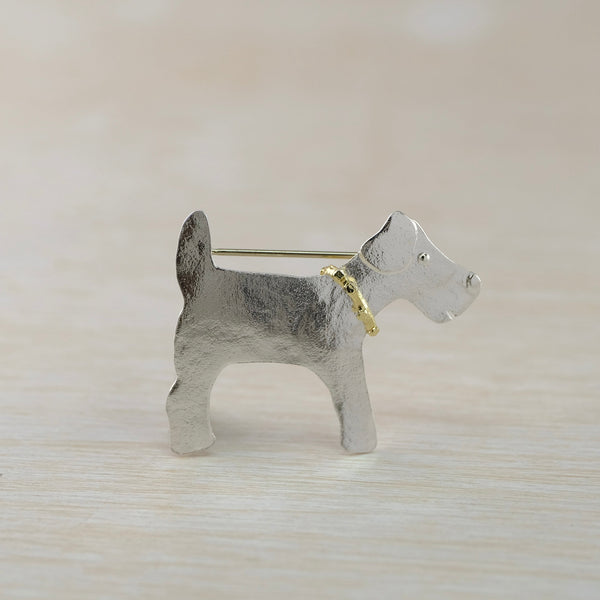 siler brooch in the shape of a dog with a gold collar