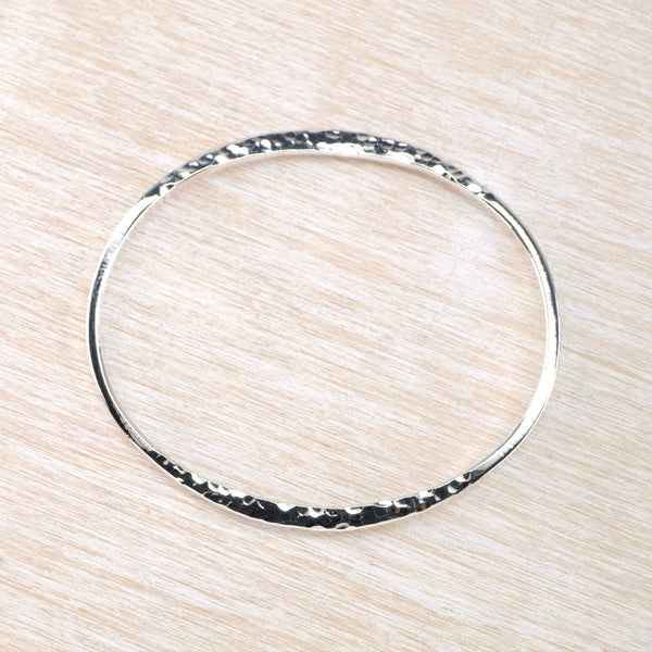 Silver bangle with flattened hammered detail.