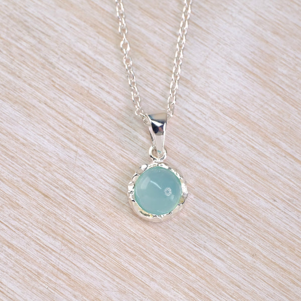 Necklace with a round light blue stone  pendant in a silver setting and a silver chain