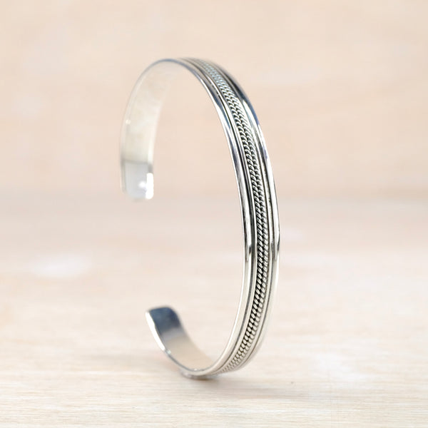 Silver torque bangle bracelet with decorative inlay.