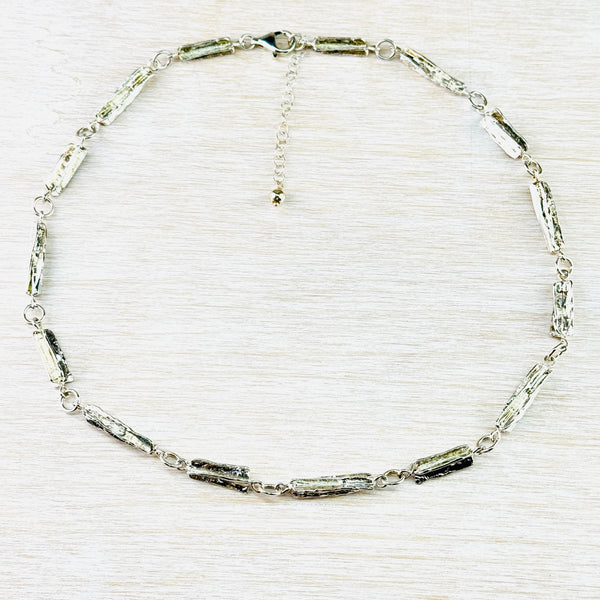 Textured silver link necklace with varying sizes of links and a lobster clasp. Textured silver link necklace with varying sizes of links and a lobster clasp.