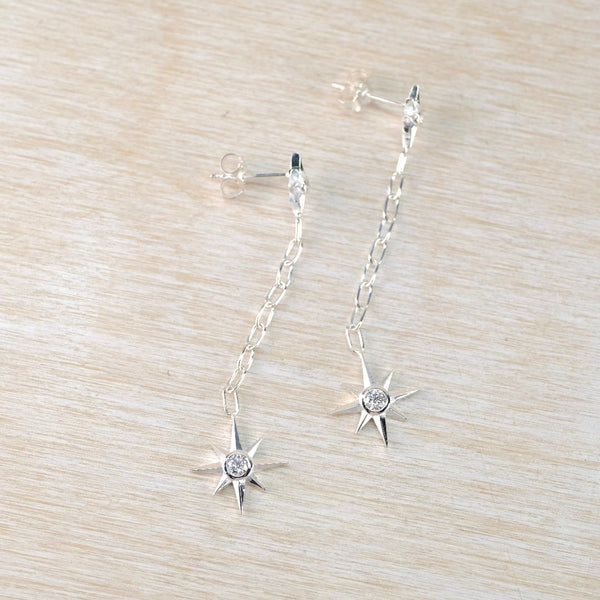 silver earrings with sparkly stars dangling from a silver chain. silver earrings with sparkly stars dangling from a silver chain.