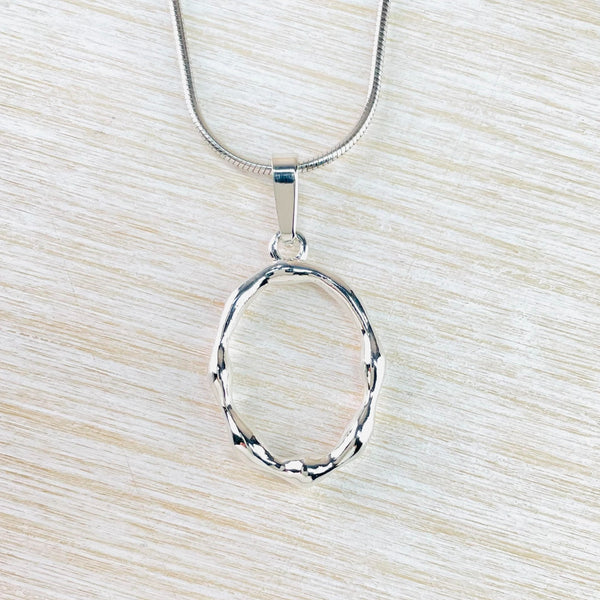 Shiny silver in an open oval shape with a regular 'lumpy' design in the silver. Simply connected to the chain by a plain silver bale. Shiny silver in an open oval shape with a regular 'lumpy' design in the silver. Simply connected to the chain by a plain silver bale.