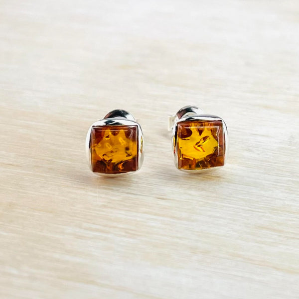 Bright amber, with little inclusions, set in a rounded square silver  surround.