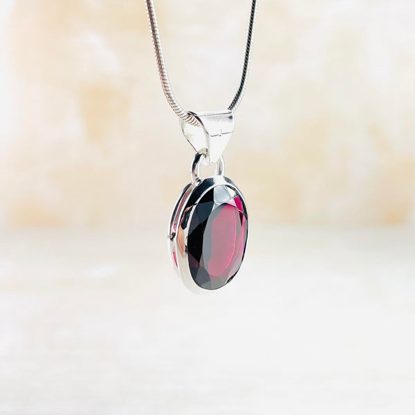 Oval Sterling Silver and Faceted Garnet Pendant.