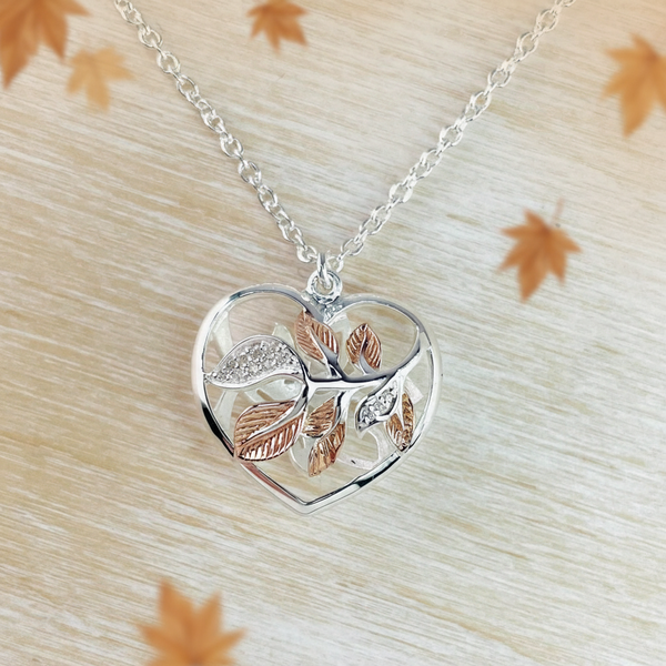 A sterling silver and rose gold plated heart pendant with zirconia leaf decorations, presented on a quality link chain.