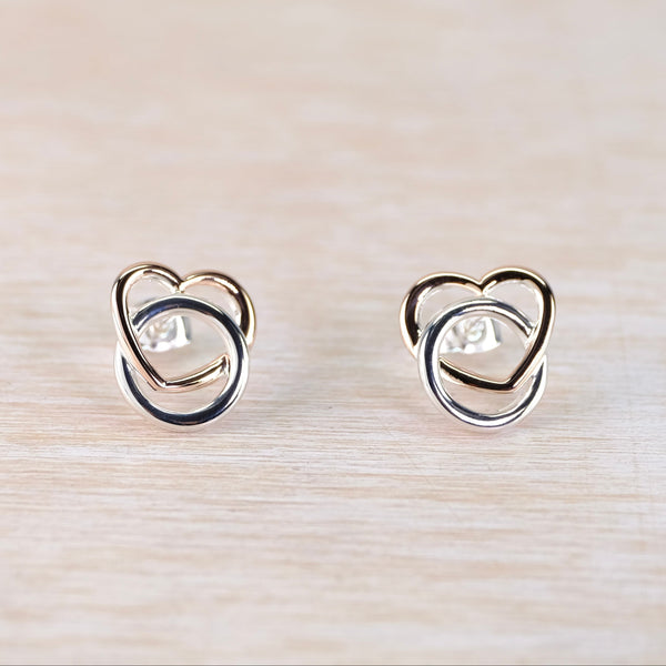 Pair of heart-shaped earrings on a light wood surface