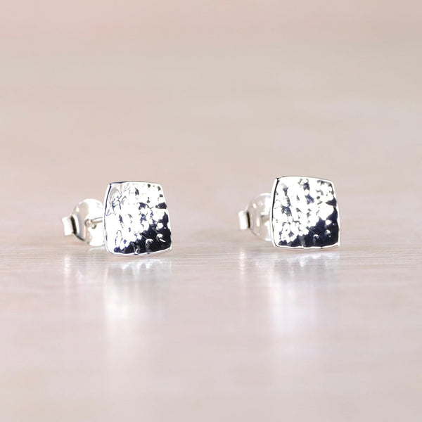 Pair of silver stud earrings on a light gray background