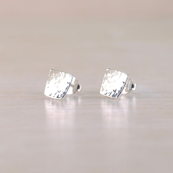 Pair of silver stud earrings on a light gray background