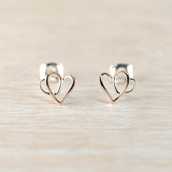 Heart-shaped earrings on a light wood background