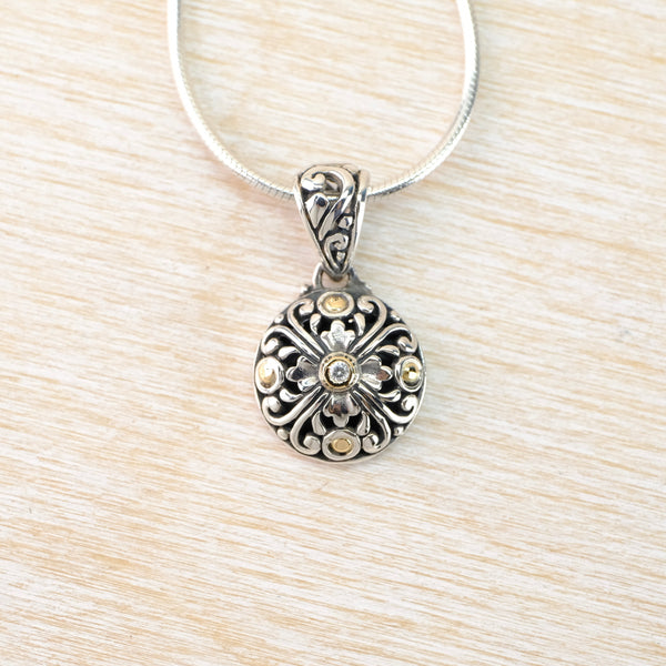 Silver pendant necklace on a light wood surface