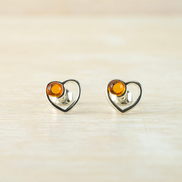 Heart-shaped earrings with amber stones on a light background