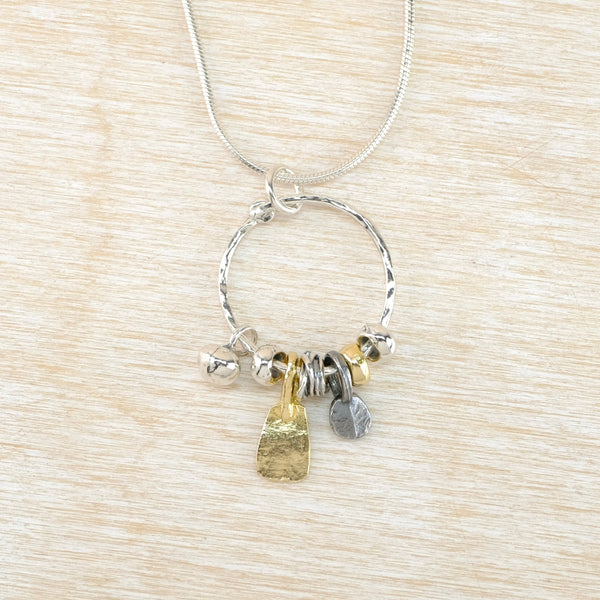 Necklace with various charms on a beige textured background
