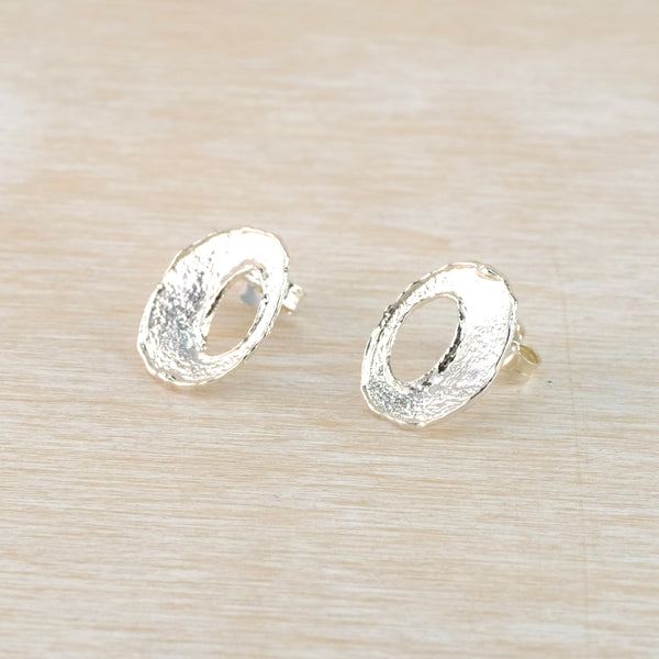Pair of silver earrings on a light wood background