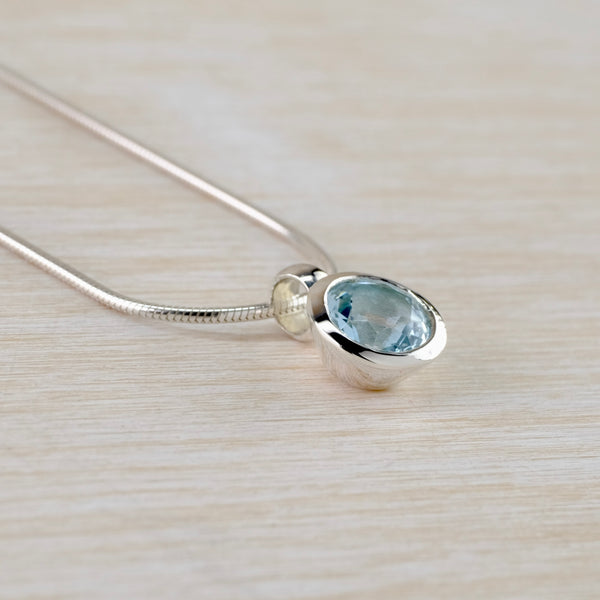 Small Round Blue Topaz and Silver Pendant.