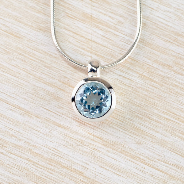 Small Round Blue Topaz and Silver Pendant.
