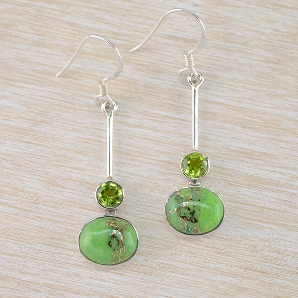 A pair of silver drop earrings with vibrant green Mojave turquoise and peridot accents.