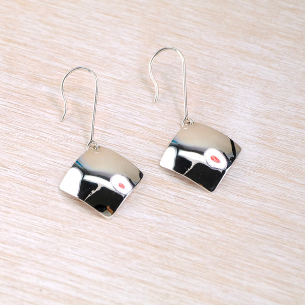 Pair of shiny silver earrings with an offset square shape