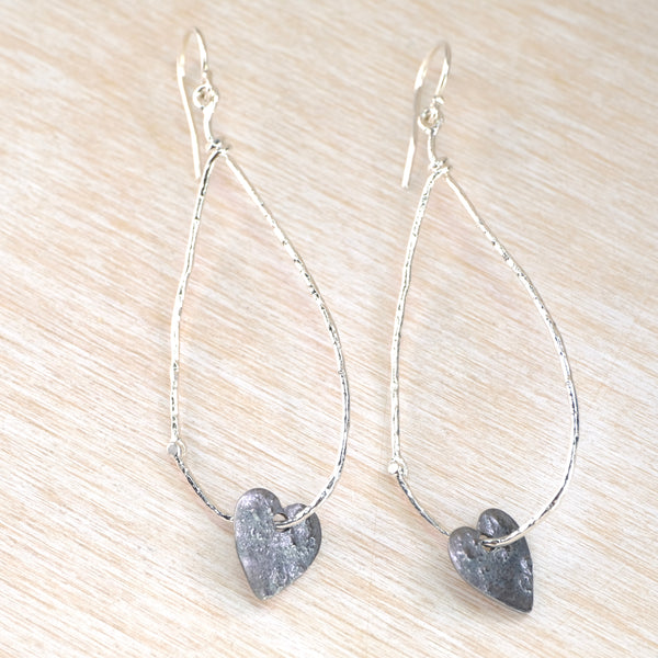 Silver teardrop outline earrings with heart-shaped charm at the bottom