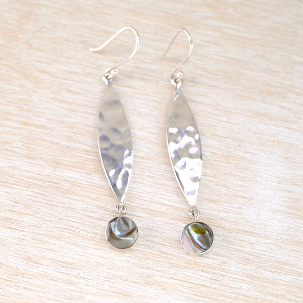 long silver earrings with a round disc of green grey abalone shell dangling at the bottom