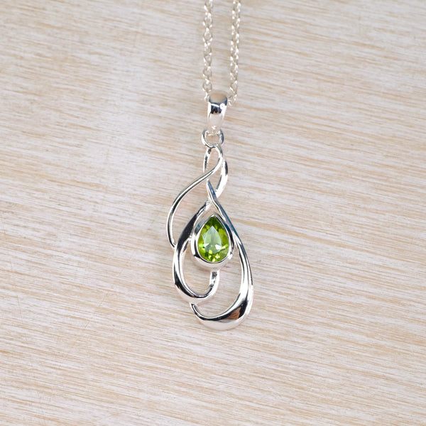 Silver pendant with a green gemstone  and silver chain.