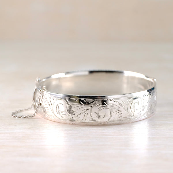 Silver bracelet with intricate designs on a light background