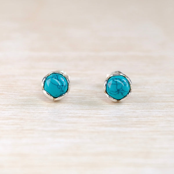 Turquoise stud earrings with scalloped silver setting.
