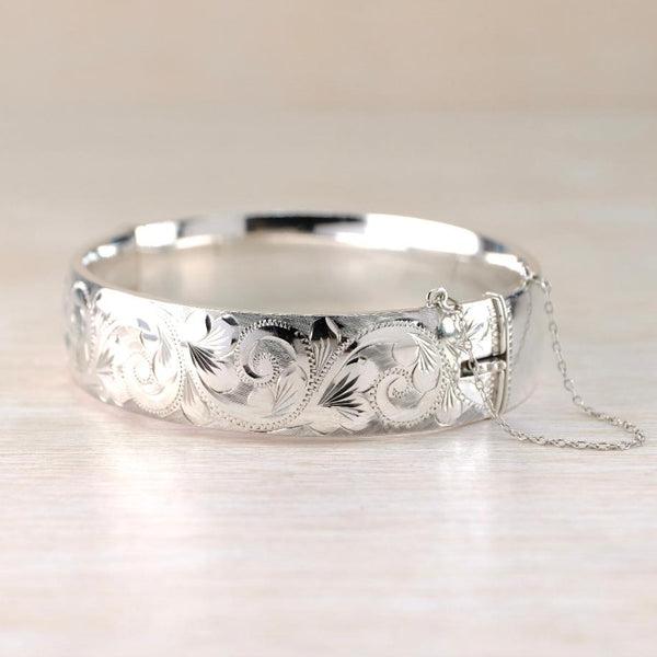 Silver bracelet with intricate designs on a light background