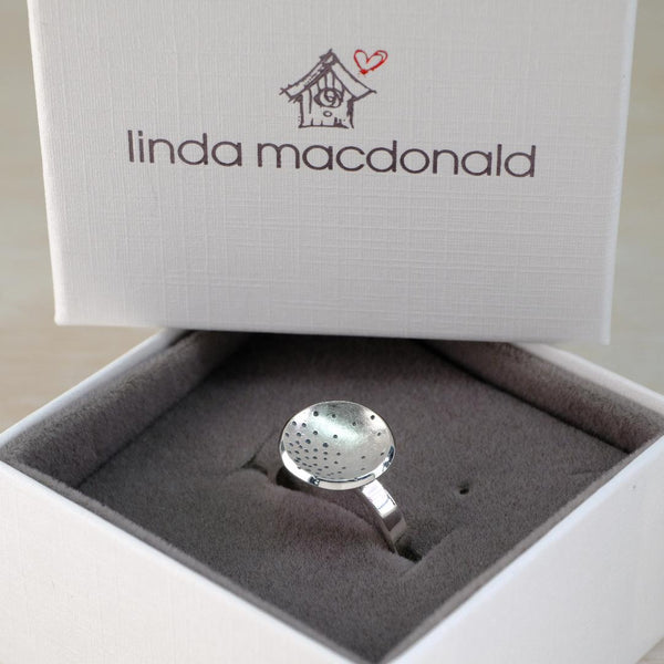 Silver ring in a box with 'linda macdonald' branding