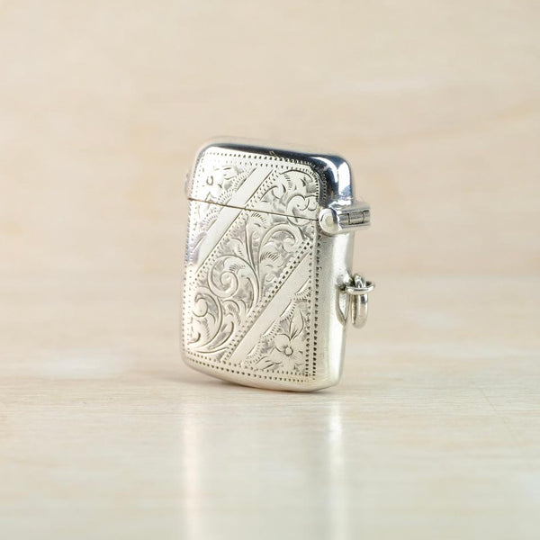 Silver engraved vesta case on a beige background