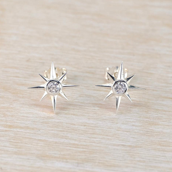 silver star shaped stud earrins with a sparkly stne set in the middle