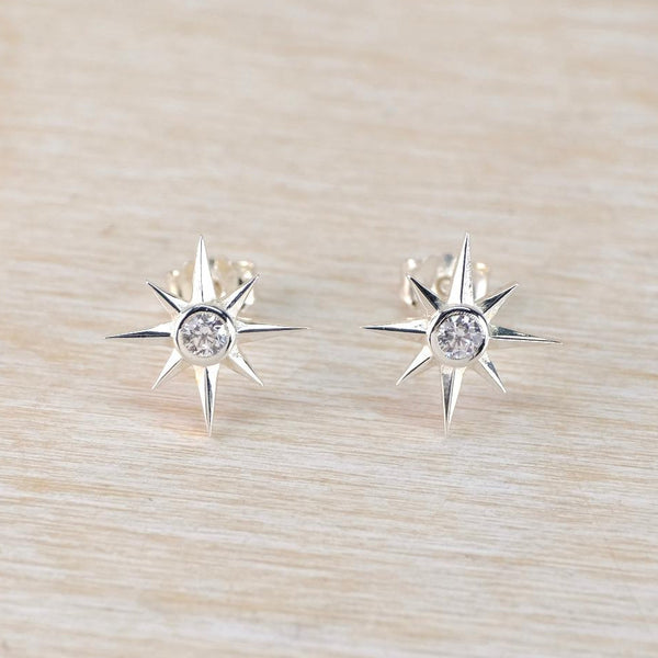 silver star shaped stud earrins with a sparkly stne set in the middle
