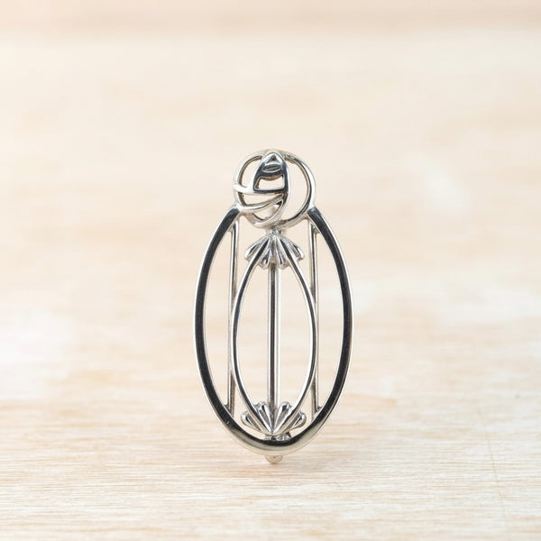Silver brooch on a beige background