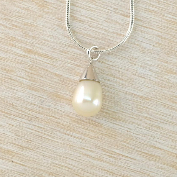 Pearl pendant necklace on a wooden surface