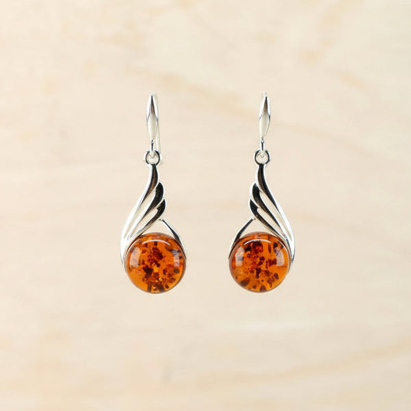 Pair of amber earrings against a beige background