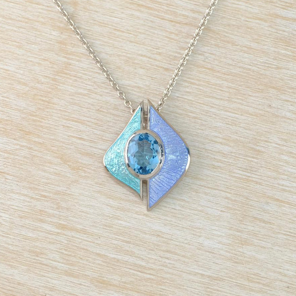 Fine enamel pendant in blues and greens, set with a deep blue topaz stone