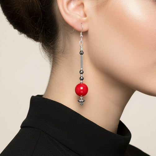 Red beaded earrings with silver hooks on a beige background