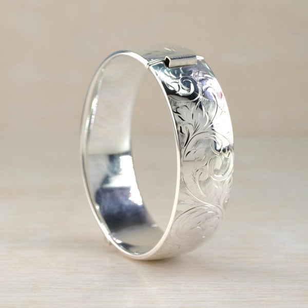 Silver bangle bracelet with intricate floral engraving 