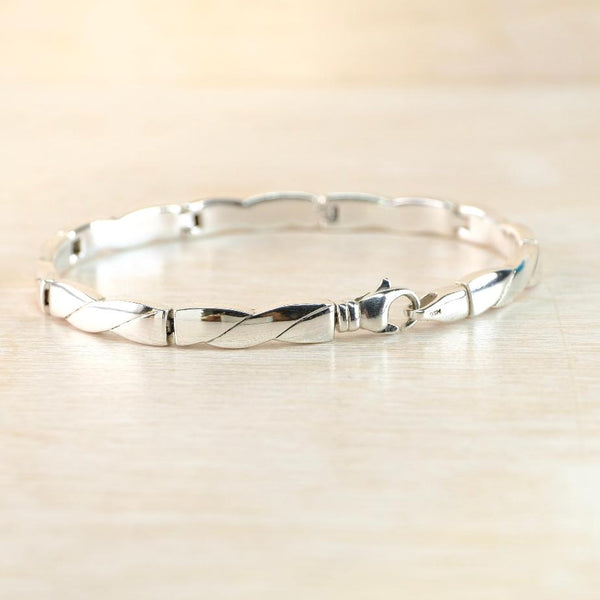 Silver bracelet on a light wooden surface