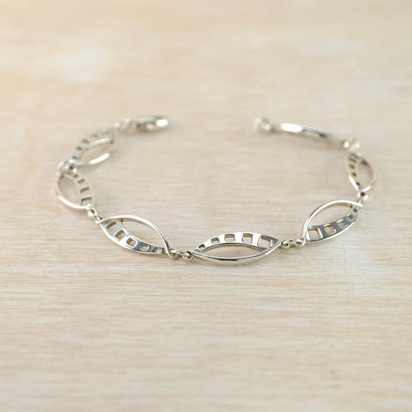 Silver bracelet on a light wood surface