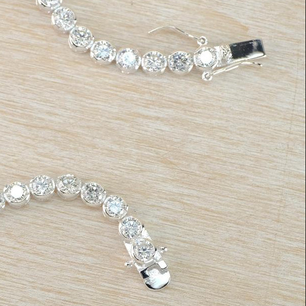Silver bracelet with clear stones on a light wooden surface