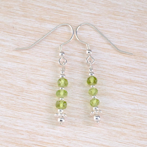 Light Green beaded earrings on a light wood surface