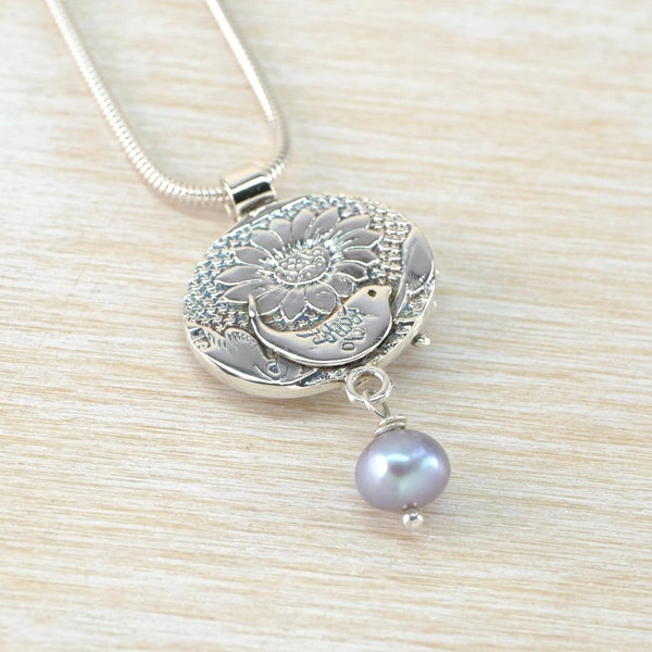 Silver necklace with a floral and bee pendant with pearl drop