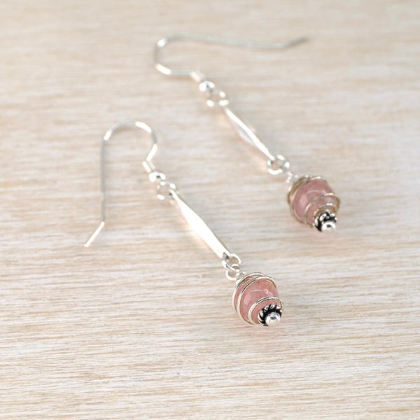 Pair of dangly earrings with pink beads wrapped in a spiral of wire.