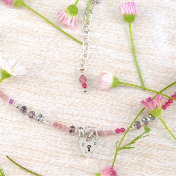 Necklace with pink and silver beads and a heart shaped padlock charm 