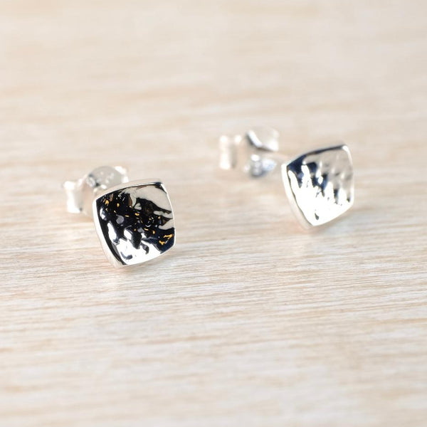 Hammered  Silver square stud earrings on a light wood surface