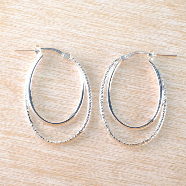 Silver hoop earrings on a wooden surface