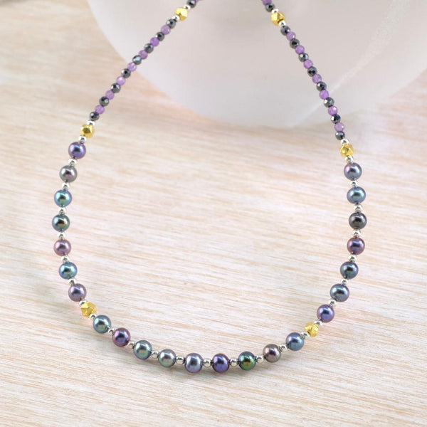 Necklace with  subtly multicolored beads with gold accents.