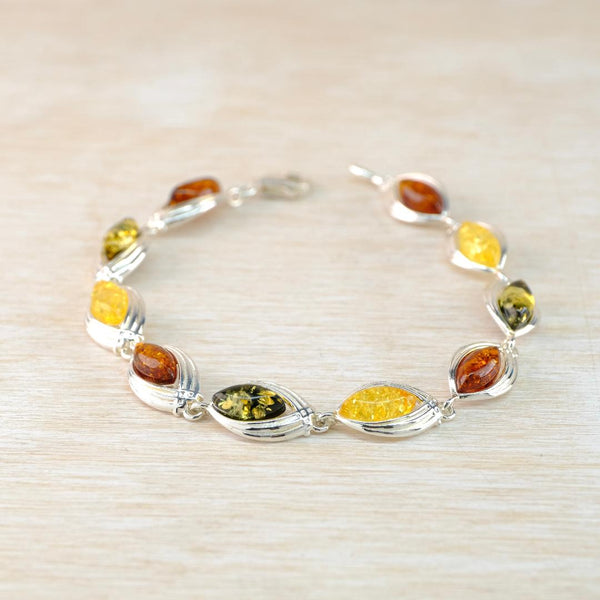 Silver bracelet with multicolored amber stones on a beige background