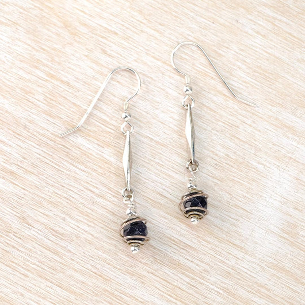  Dangly Silver earrings with black beads enclosed in a spiral wire.
